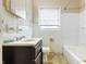Modest bathroom featuring a single sink vanity, toilet, and tiled shower and tub at 4013 Priscilla Ave, Indianapolis, IN 46226