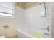 Bathroom featuring a tub and shower combo with white tile surround and a small window at 4013 Priscilla Ave, Indianapolis, IN 46226