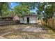 Well-maintained backyard showcasing a white house with black accents, including a door and roof, within a wooden fence at 516 N Chester Ave, Indianapolis, IN 46201