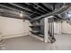 Spacious basement area with open ceiling, painted walls, and access to stairs and storage at 516 N Chester Ave, Indianapolis, IN 46201