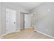 Bedroom with two doors, light gray walls, and laminate flooring creating a bright and inviting space at 516 N Chester Ave, Indianapolis, IN 46201
