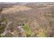 Aerial view of a home with a deck and manicured lawn surrounded by mature trees and a serene landscape at 534 1/2 Amos Dr, Zionsville, IN 46077