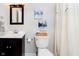 Cozy bathroom featuring a dark wood vanity, toilet, and bathtub-shower combo with decorative wall art at 534 1/2 Amos Dr, Zionsville, IN 46077