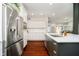 Modern kitchen featuring stainless steel refrigerator, white cabinets, and hardwood floors at 534 1/2 Amos Dr, Zionsville, IN 46077