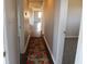 View down hallway of home with floral rug on wood floor at 5582 E State Road 144, Mooresville, IN 46158
