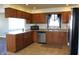 Bright kitchen features tile floors, wooden cabinets, stainless steel appliances and a corner sink at 5582 E State Road 144, Mooresville, IN 46158