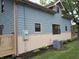 Corner exterior featuring blue siding and beige lower siding, energy meter, AC unit, and fresh landscaping at 5603 S Randolph St, Indianapolis, IN 46227