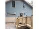 Side exterior of a two-story home with blue siding, beige accents, and a new deck with wooden railings and stairs at 5603 S Randolph St, Indianapolis, IN 46227