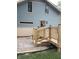 Side exterior of a two-story home with blue siding, beige accents, and a new deck with wooden railings and stairs at 5603 S Randolph St, Indianapolis, IN 46227