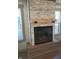 Close-up of the stone fireplace with a wood mantel and black trim at 5603 S Randolph St, Indianapolis, IN 46227