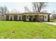 Charming single story brick home with well-maintained lawn and inviting front porch at 5909 Furnas Rd, Indianapolis, IN 46221
