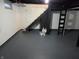A large unfinished basement with painted floors and walls and exposed pipes at 5915 Winthrop Ave, Indianapolis, IN 46220