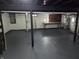 A large unfinished basement with painted floors and walls and exposed pipes at 5915 Winthrop Ave, Indianapolis, IN 46220