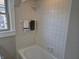 Updated bathroom featuring white tile, modern fixtures, and a bright window at 5915 Winthrop Ave, Indianapolis, IN 46220