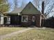 Charming brick home with a screened-in porch, arched front door, and well-maintained lawn at 5915 Winthrop Ave, Indianapolis, IN 46220