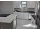 Bright kitchen featuring white cabinets, subway tile, stainless steel appliances, and island with cooktop at 5915 Winthrop Ave, Indianapolis, IN 46220