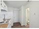 Bright kitchen featuring white cabinets and appliances, with wood-look flooring at 6663 Black Antler Cir, Indianapolis, IN 46217