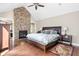 Tranquil bedroom with a stone fireplace, a king-size bed, and natural light at 6980 N Pennsylvania St, Indianapolis, IN 46220