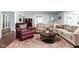 Cozy living room with a large sectional sofa, a leather armchair, and a round coffee table on a patterned rug at 6980 N Pennsylvania St, Indianapolis, IN 46220