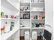 Walk-in pantry with white shelves stocked with various household items and food at 6980 N Pennsylvania St, Indianapolis, IN 46220