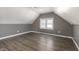 Well-lit attic with hardwood floors and a double hung window providing natural light to the room at 712 N Pendleton Ave, Pendleton, IN 46064