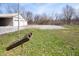 A backyard featuring a large lawn, a gravel parking area and an outbuilding with multiple bays at 712 N Pendleton Ave, Pendleton, IN 46064