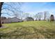 Beautiful backyard featuring a large lawn, mature trees, and an outbuilding and home in the background at 712 N Pendleton Ave, Pendleton, IN 46064