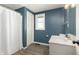 Bathroom with a vanity, toilet, and shower-tub combination, featuring a blue wall and wood-look flooring at 712 N Pendleton Ave, Pendleton, IN 46064