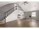 Bright, open-concept living space with wood floors, a ceiling fan, and a staircase to a loft at 712 N Pendleton Ave, Pendleton, IN 46064