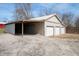 Outbuilding featuring three garage bays and an open bay, with gravel in the foreground at 712 N Pendleton Ave, Pendleton, IN 46064