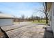Spacious concrete tile patio area with a view of the yard and metal outbuilding at 712 N Pendleton Ave, Pendleton, IN 46064