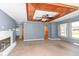 Open living room featuring a fireplace, ceiling fan, and multiple entryways at 7401 E 56Th St, Indianapolis, IN 46226