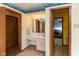 Bathroom with a pink vanity featuring a large mirror, doorway to the hall, and an adjacent closet at 8331 Lookout Ct, Indianapolis, IN 46217