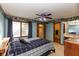 Cozy bedroom featuring blue walls, patterned wallpaper trim, and a ceiling fan with an attached full bathroom and closet at 8331 Lookout Ct, Indianapolis, IN 46217