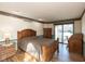 Spacious bedroom featuring hardwood floors, a wooden bed frame, and a sliding glass door to the outside at 8331 Lookout Ct, Indianapolis, IN 46217