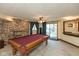 Basement game room featuring a pool table, a stone fireplace, and sliding glass doors for natural light at 8331 Lookout Ct, Indianapolis, IN 46217