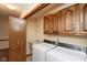 Functional laundry room with cabinetry, sink, washer and dryer hookups, and a doorway to another space at 8331 Lookout Ct, Indianapolis, IN 46217