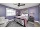 Cozy bedroom with violet walls, a ceiling fan, a comfy chair, and stylish decor at 10479 Dusty Rose Dr, Zionsville, IN 46077