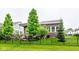 Landscaped backyard featuring a covered patio and manicured lawn behind a black fence at 12167 Ams Run, Carmel, IN 46032