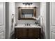 Bathroom vanity featuring a wood cabinet, white countertop, vessel sink, and rustic-style mirror at 12167 Ams Run, Carmel, IN 46032