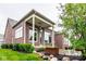 Brick home featuring a covered patio, ceiling fan, and manicured landscaping at 12167 Ams Run, Carmel, IN 46032
