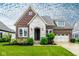 Charming brick home featuring a stone facade, manicured lawn, and a welcoming three-car garage at 12167 Ams Run, Carmel, IN 46032