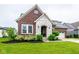Inviting brick and stone home with a well-maintained lawn and a convenient three-car garage at 12167 Ams Run, Carmel, IN 46032