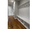 Hallway featuring a built-in storage bench, coat rack, and wood-look flooring at 12167 Ams Run, Carmel, IN 46032