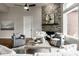 Bright living room features a stone fireplace, modern ceiling fan, and stylish furnishings at 12167 Ams Run, Carmel, IN 46032