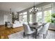 Open-concept living and dining area with hardwood floors, large windows, and a brick accent wall at 12167 Ams Run, Carmel, IN 46032