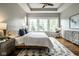 Bright main bedroom with hardwood floors, a ceiling fan, and large windows overlooking the neighborhood at 12167 Ams Run, Carmel, IN 46032