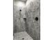 Tiled walk-in shower featuring a rainfall shower head, built-in shelf, and gray marble-patterned tiles at 12167 Ams Run, Carmel, IN 46032