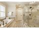 Elegant bathroom featuring a soaking tub and glass-enclosed shower with neutral tile surround at 13018 Deerstyne Green St, Carmel, IN 46032