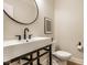 Modern powder room featuring a unique black framed mirror and sink with black fixtures at 13018 Deerstyne Green St, Carmel, IN 46032